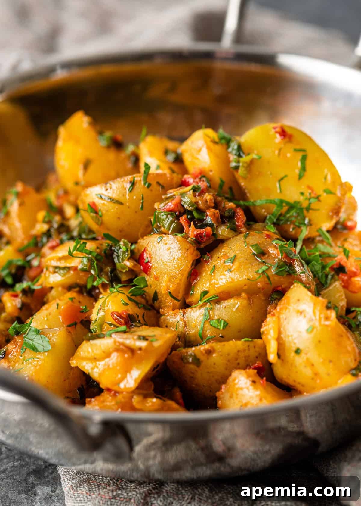 Closeup of finished Calabrian potatoes beautifully topped with extra chili and herb butter, highlighting the rich flavors.