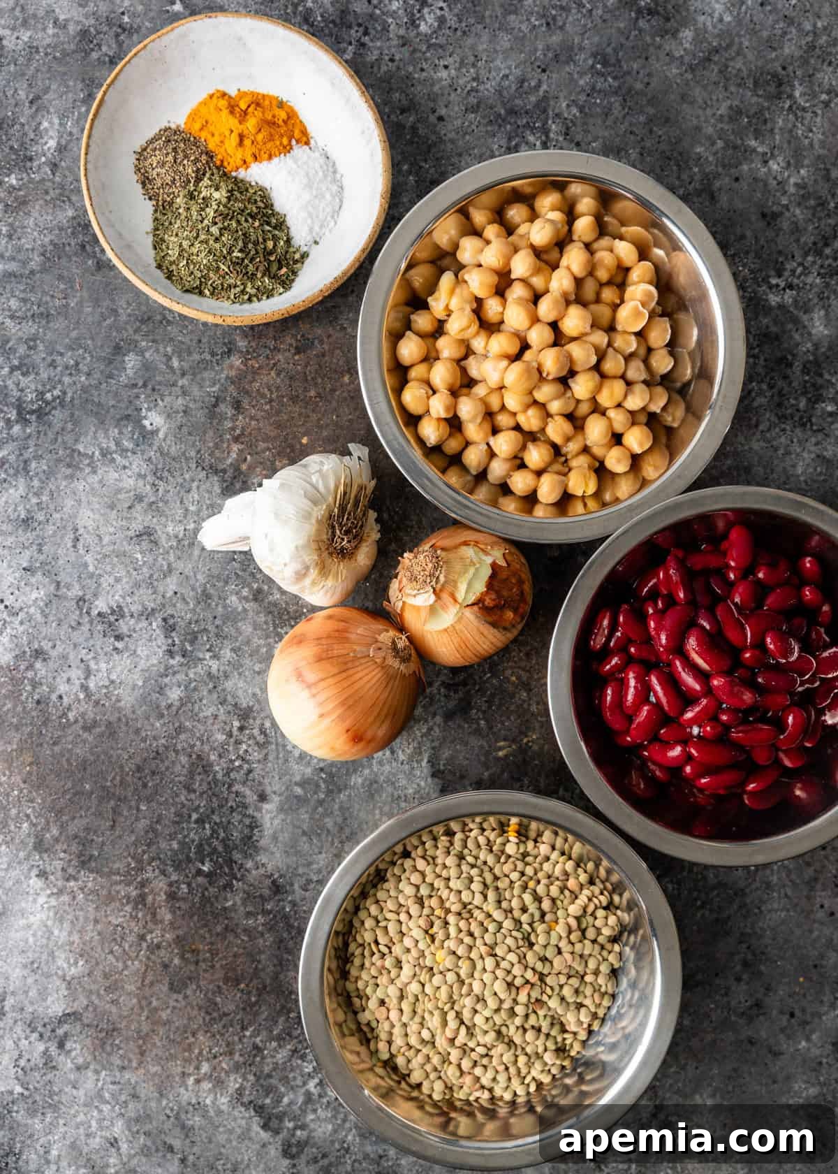 Overhead view of various ingredients for Ash Reshteh laid out in small bowls.
