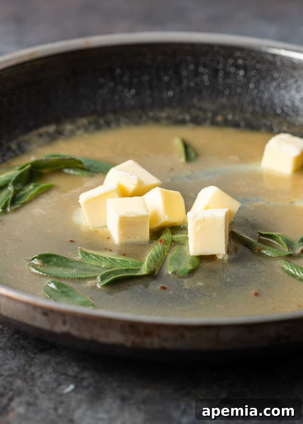 Side view process shot: Creating the rich sage butter sauce in the skillet after the meat has been removed.