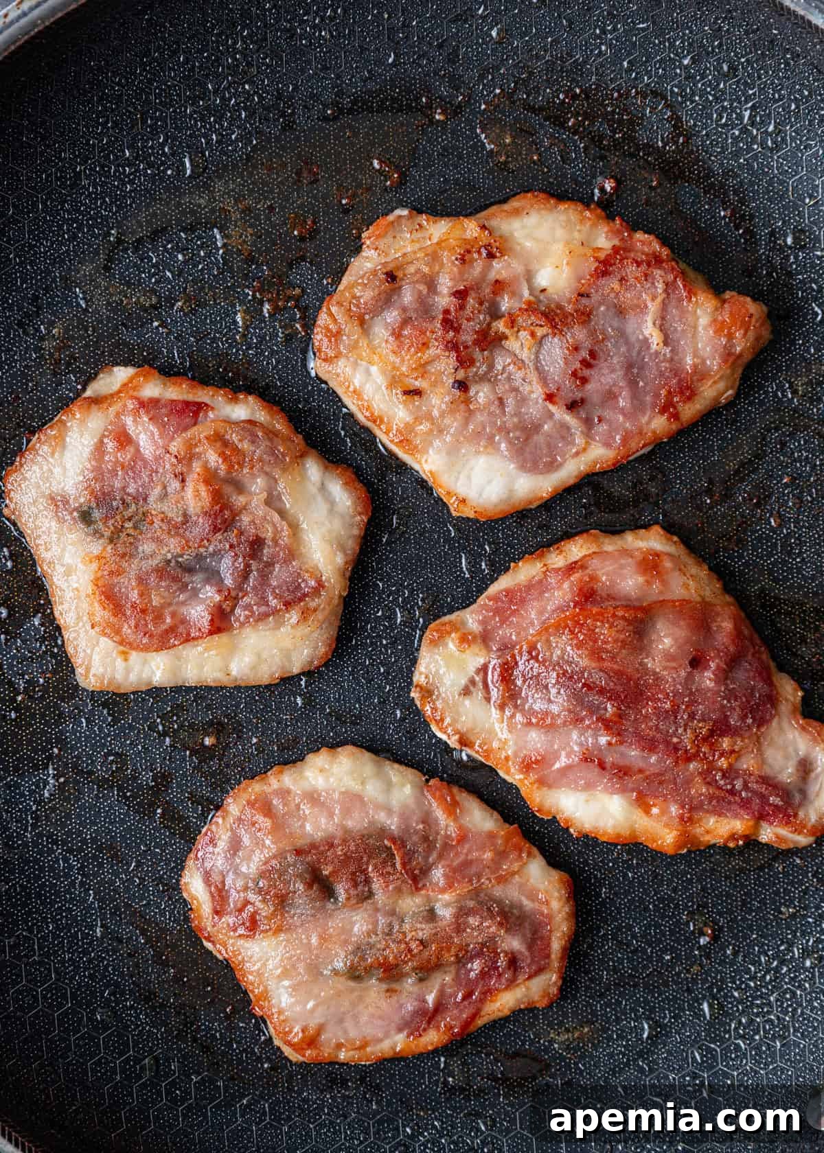 Process shot: Frying the Saltimbocca cutlets, prosciutto-side down, in a hot skillet with olive oil.