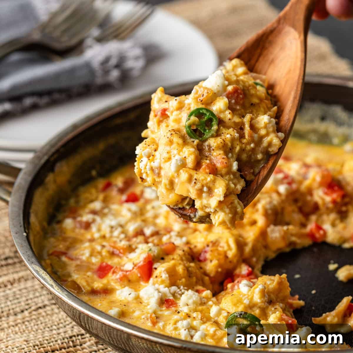 Menemen Classic Turkish Breakfast Scramble 2 A wooden spoon serving perfectly cooked menemen from a rustic cast-iron skillet, garnished with fresh herbs.