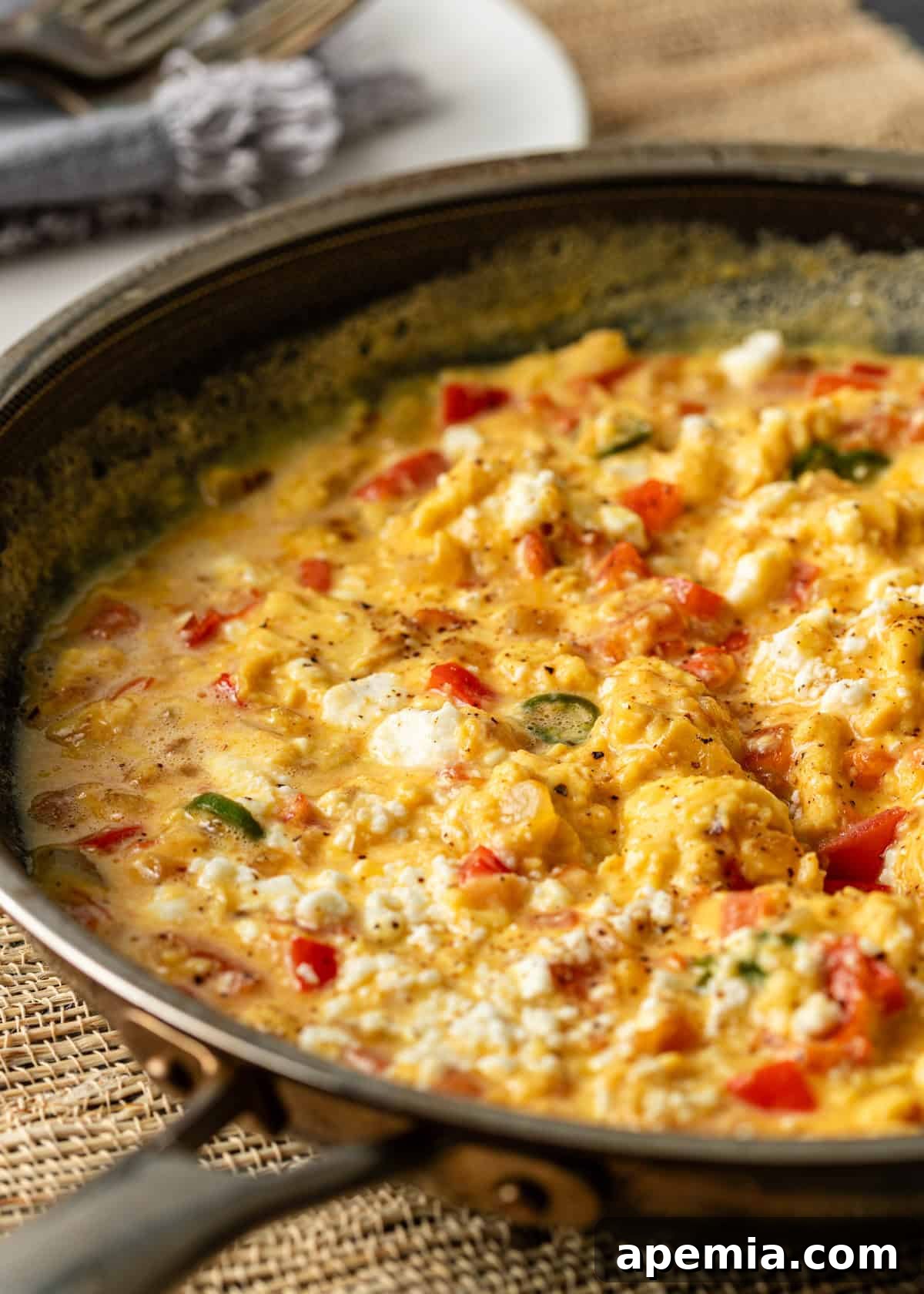 Menemen Classic Turkish Breakfast Scramble 3 Closeup shot of menemen recipe cooking in a hot skillet, showing vibrant red tomatoes and green peppers.