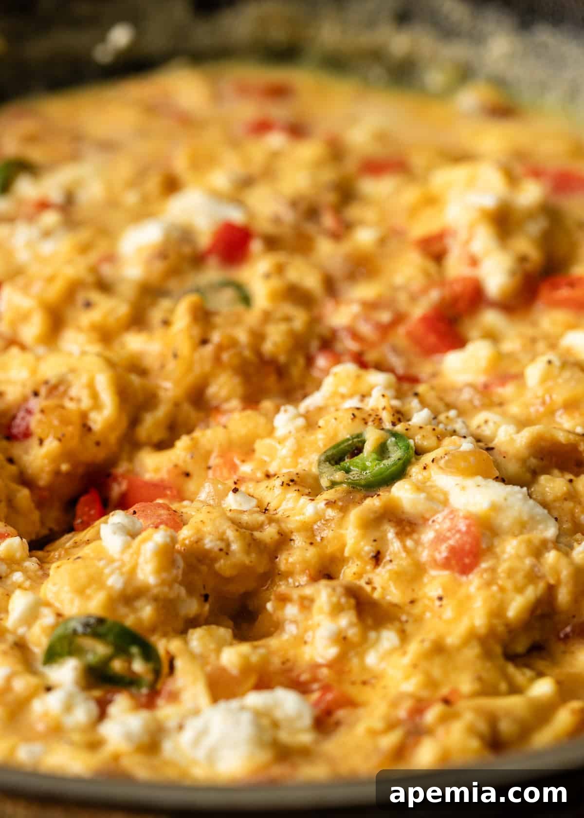Menemen Classic Turkish Breakfast Scramble 7 Extreme closeup of menemen with vibrant hot peppers and crumbled feta cheese on top, ready to serve.