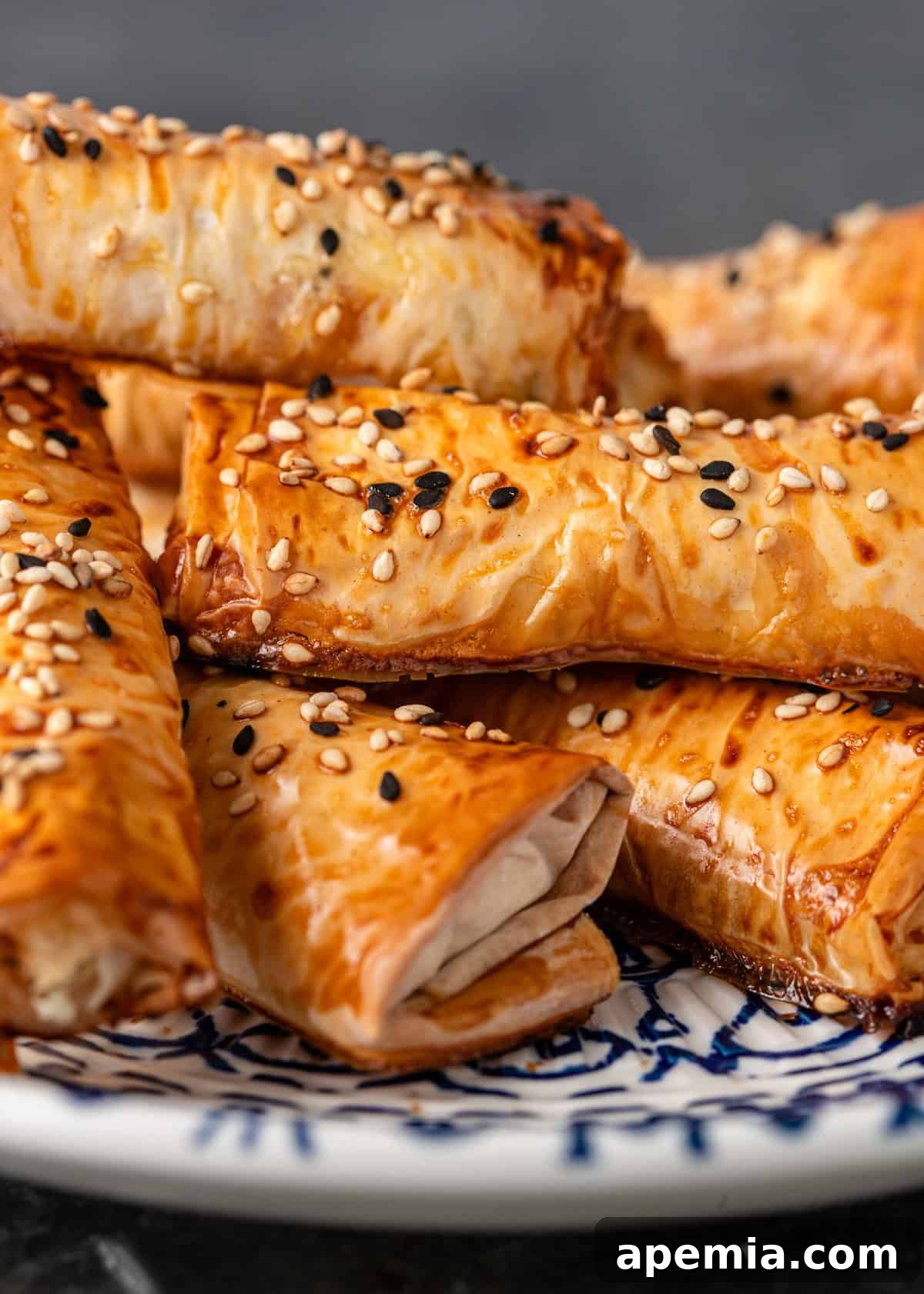 Golden Feta Börek Rolls 11 Extreme closeup: perfectly golden Turkish cheese cigars dusted with nigella and sesame seeds, highlighting their crispy texture.