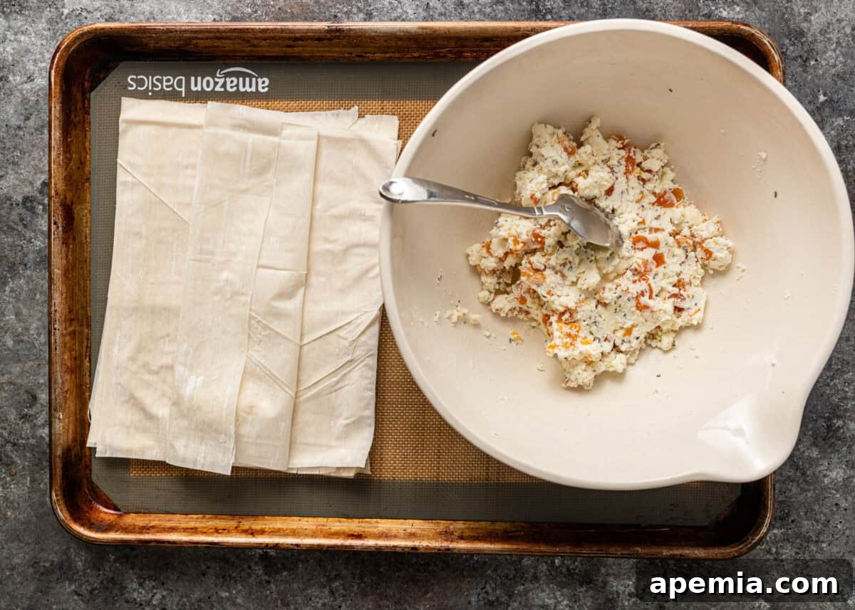 Golden Feta Börek Rolls 7 Overhead process shot: Folding the bottom corners of the phyllo dough over the filling before rolling.