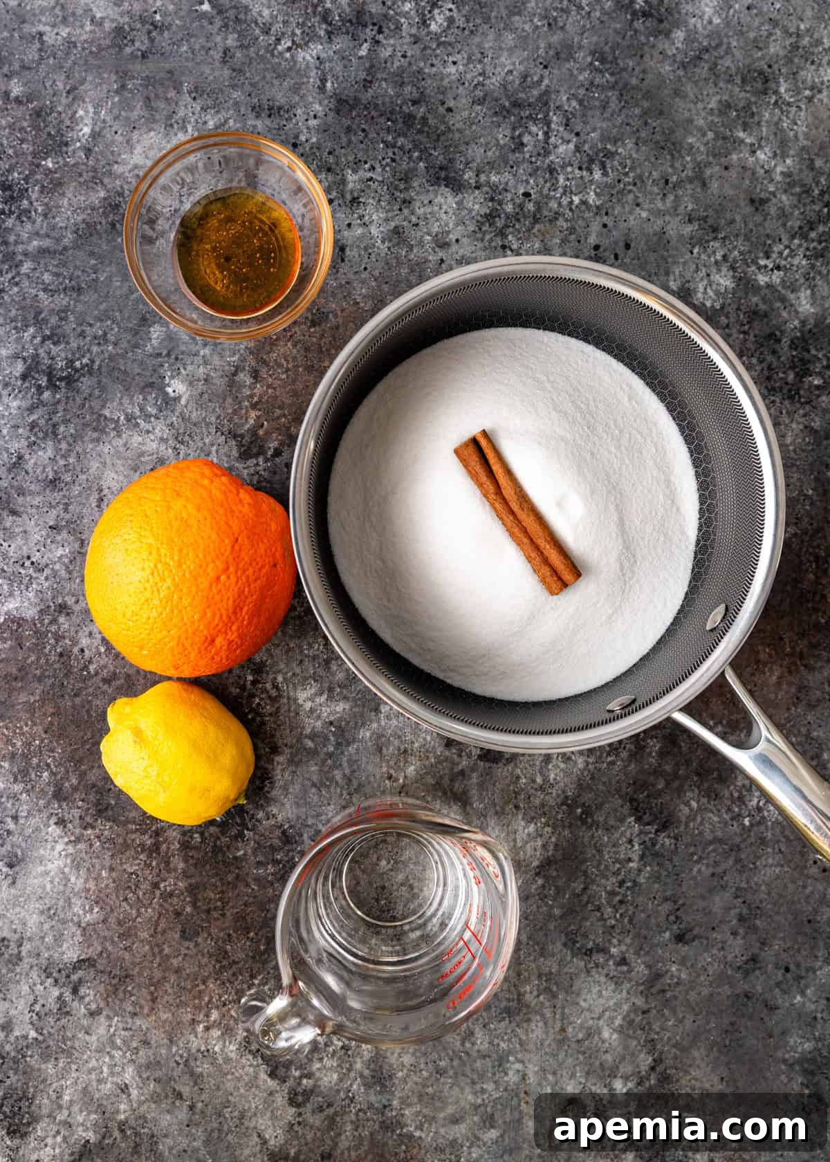 Overhead shot of various fresh ingredients laid out on a counter, essential for preparing phyllo custard pie, including eggs, milk, sugar, and oranges.