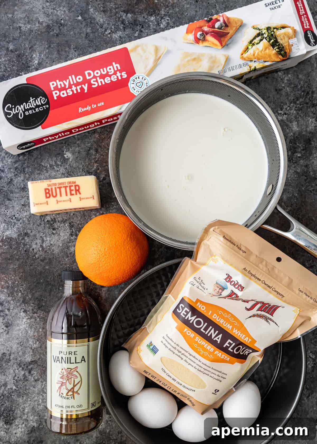 Another overhead shot displaying more ingredients for filo custard pie, such as semolina, vanilla extract, butter, and cinnamon sticks, ready for use.