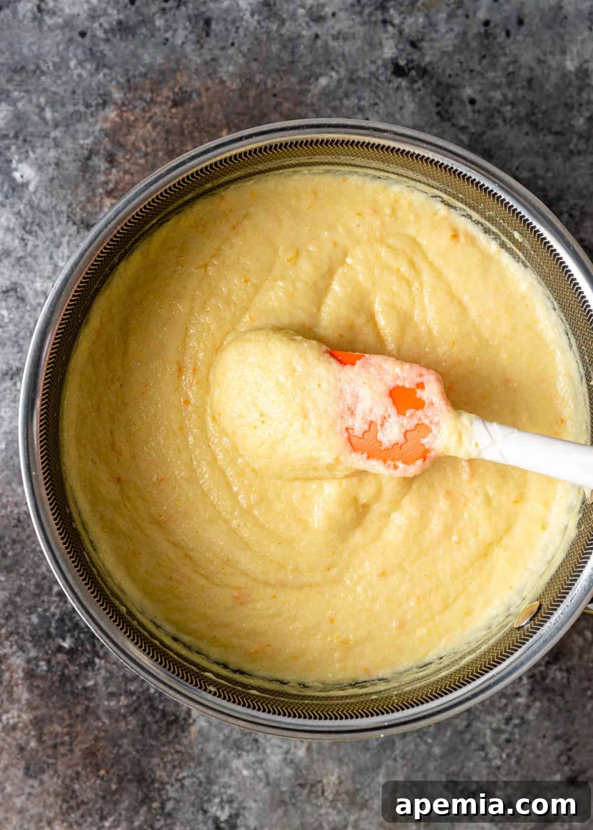 Overhead process shot demonstrating the initial steps of making the creamy custard filling for Galaktoboureko in a saucepan.