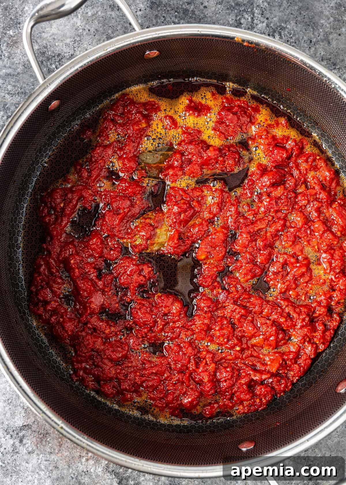 Process shot: The perfectly finished ruby chicken sauce, rich and thick, resting in a skillet.