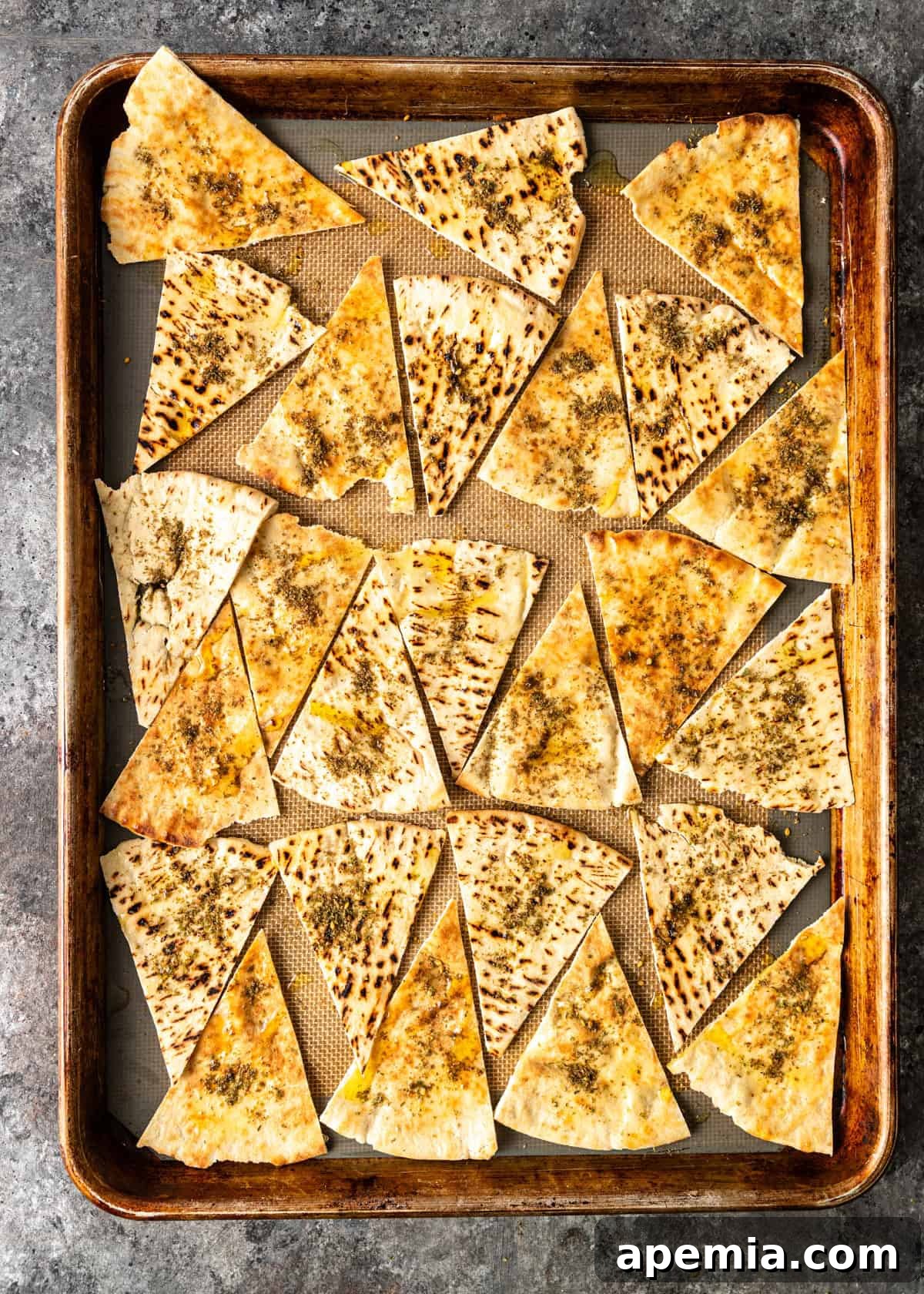 overhead: pita triangles on a baking sheet topped with spices