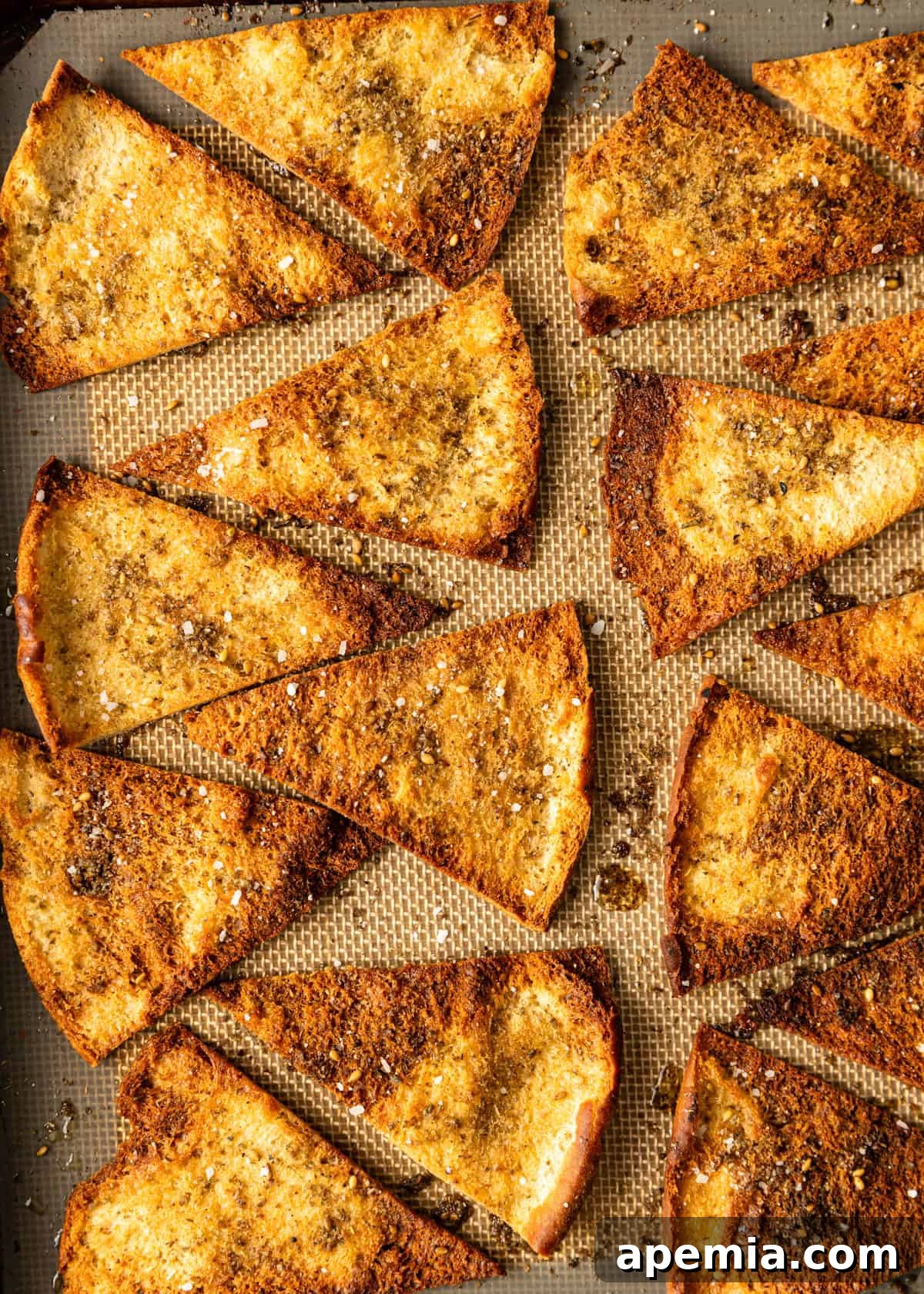 overhead closeup: baked pita chips on a baking sheet