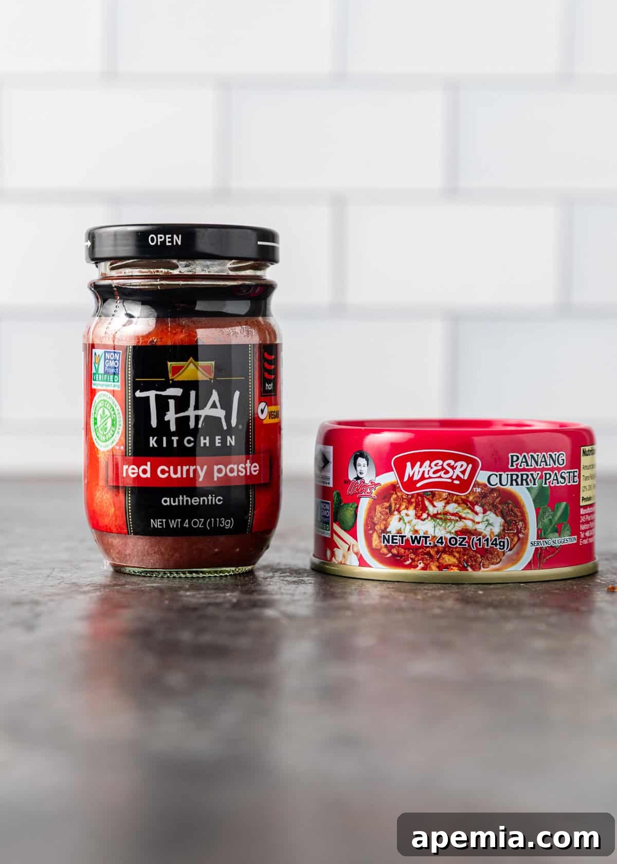 A side view highlighting an array of different brands and types of red curry paste bottles, essential for achieving authentic Thai flavors.