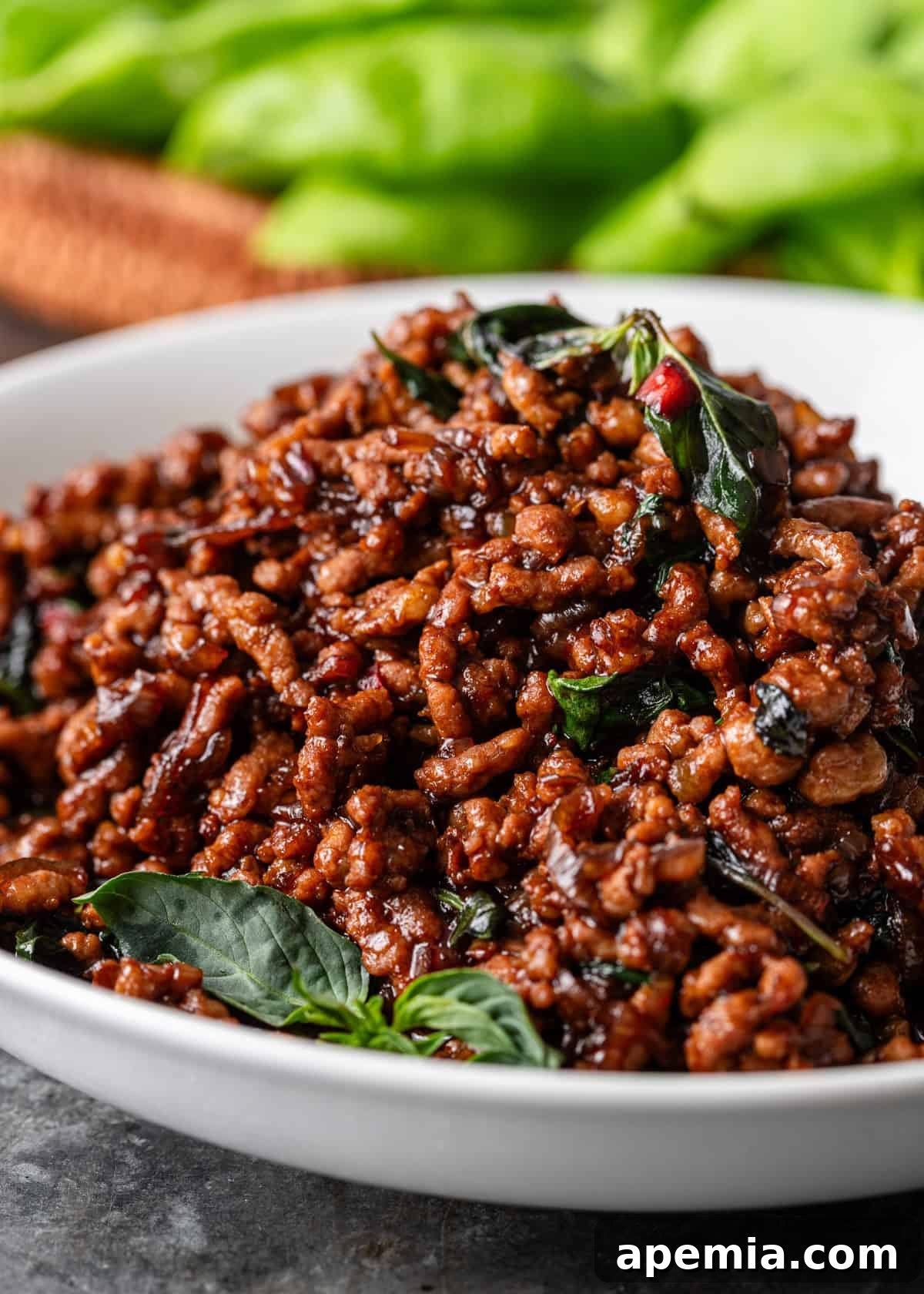side view closeup: a bowl of pad krapow with holy basil on top