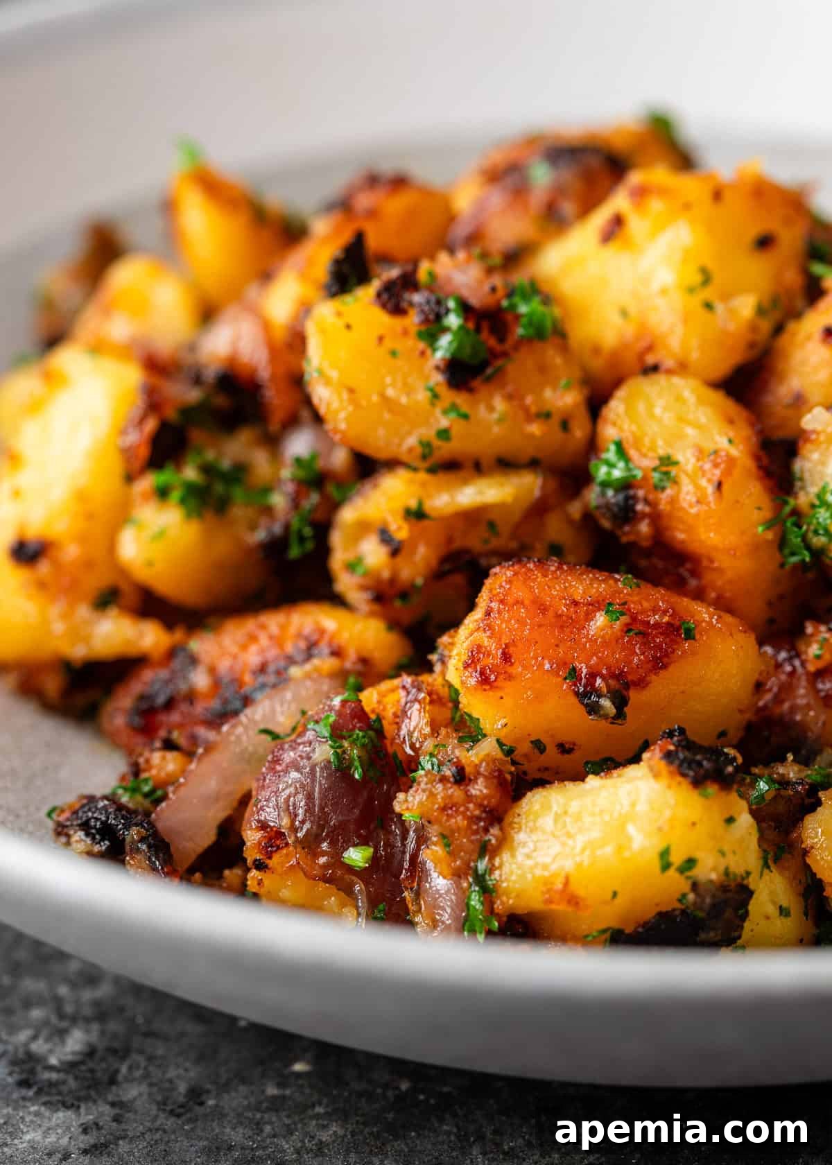 extreme closeup: roasted miso potatoes with sautéed onions and fresh herbs