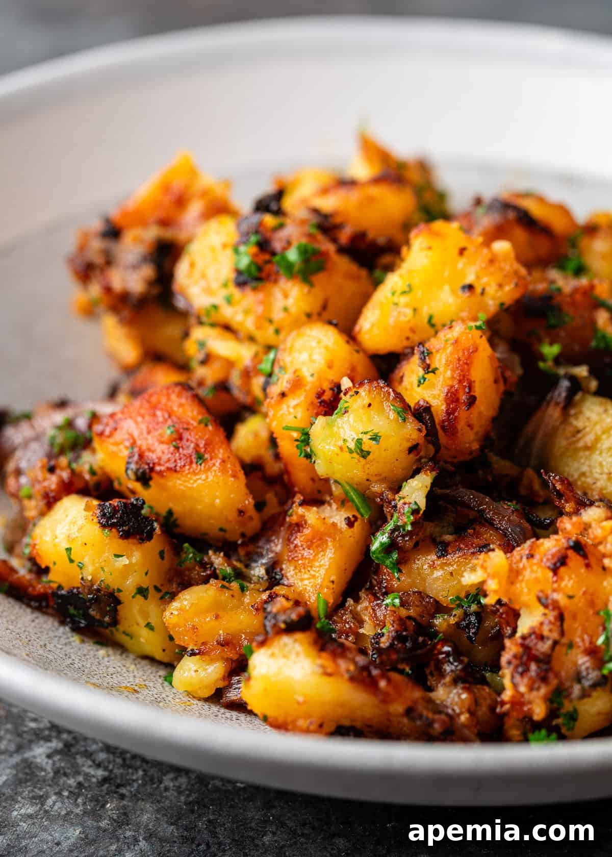 closeup: roasted miso potatoes with sautéed onions and fresh herbs