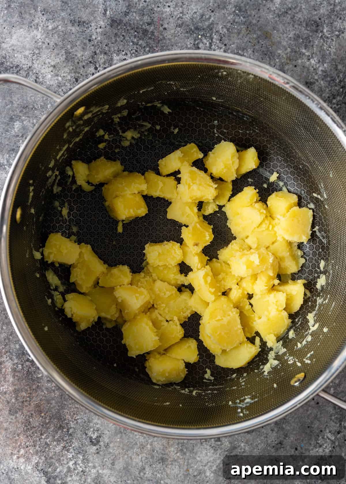 overhead process shot: drained and tossed potatoes in a pot