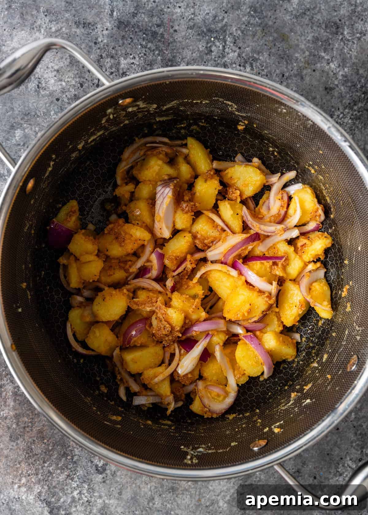 overhead process shot: potatoes tossed with spices and ready for roasting