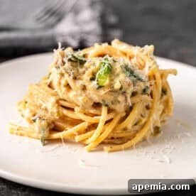 Swirled lemon zucchini pasta on a plate, garnished with fresh mint