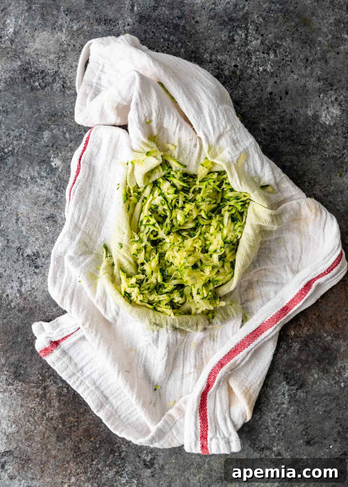 Overhead view: grated zucchini after being squeezed in a kitchen towel to remove excess moisture