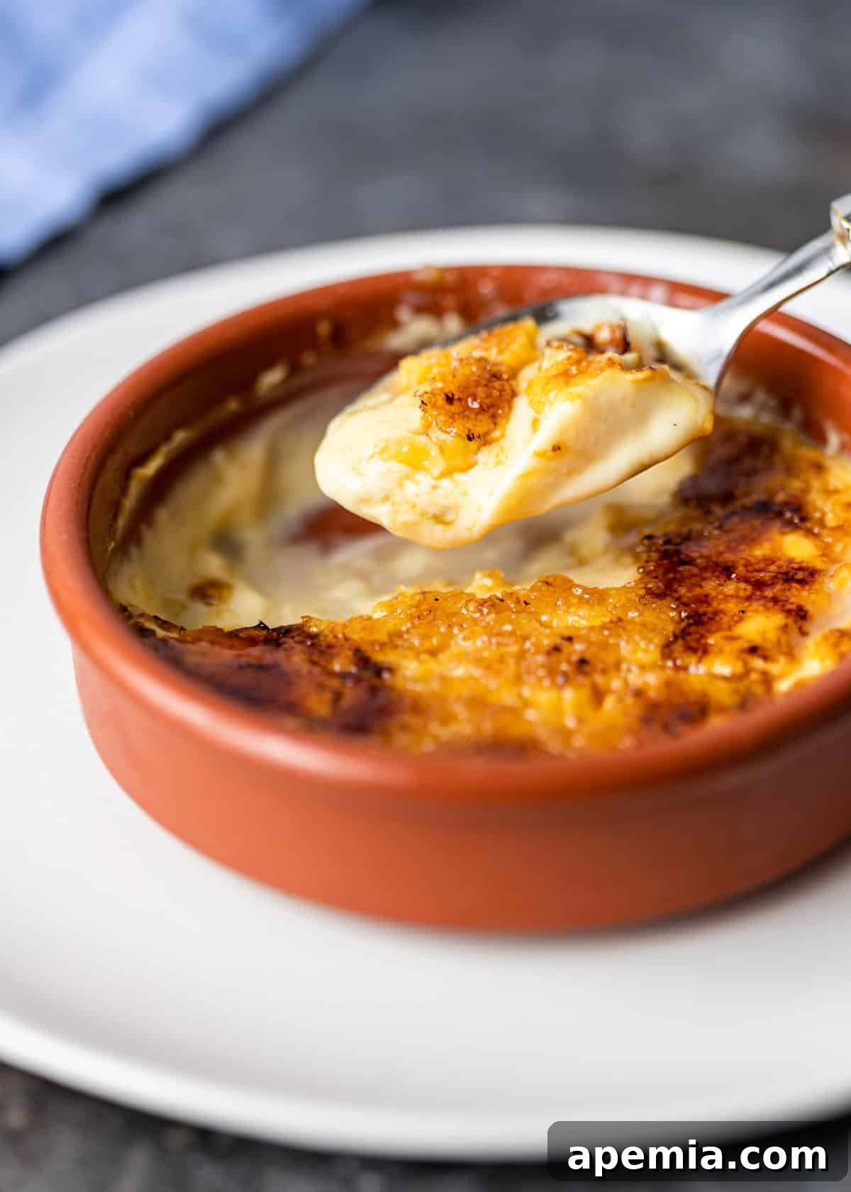 closeup: a spoonful of Spanish custard over a ramekin 