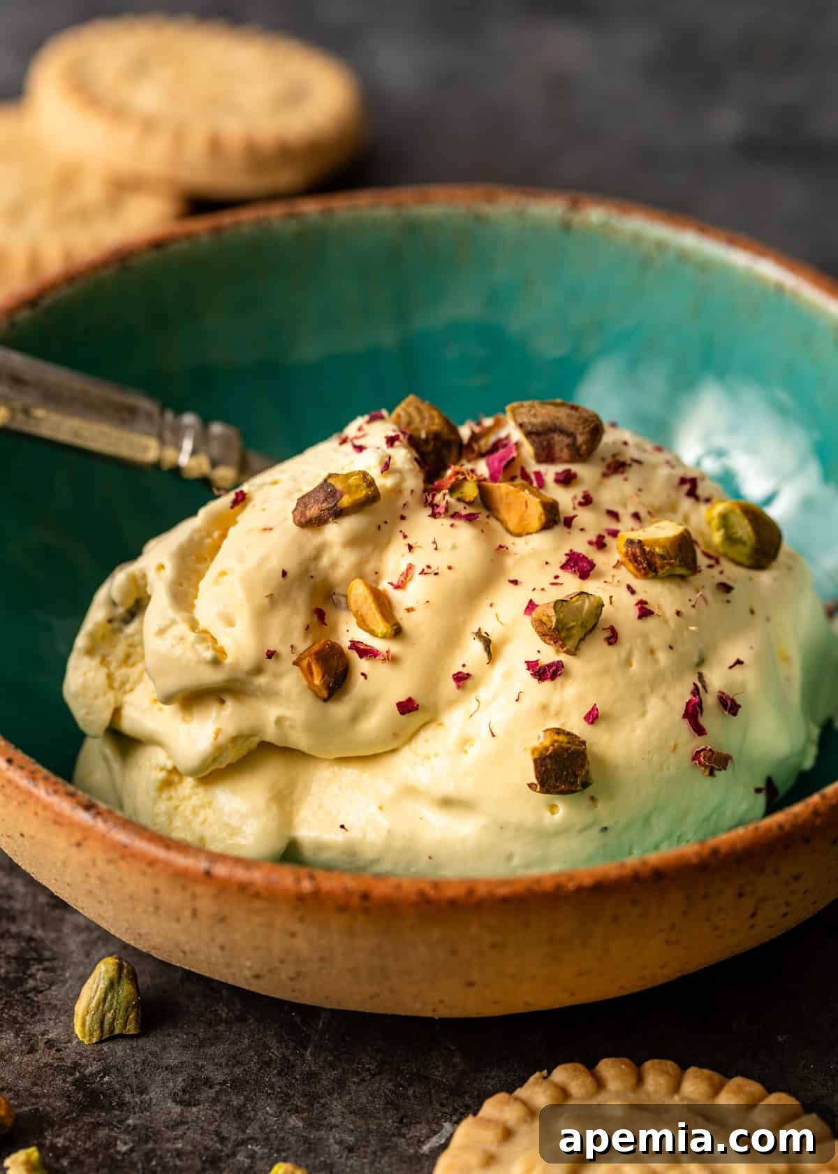 Closeup side view: A serving of my homemade Persian ice cream recipe, artfully topped with crushed nuts and delicate rose petals.