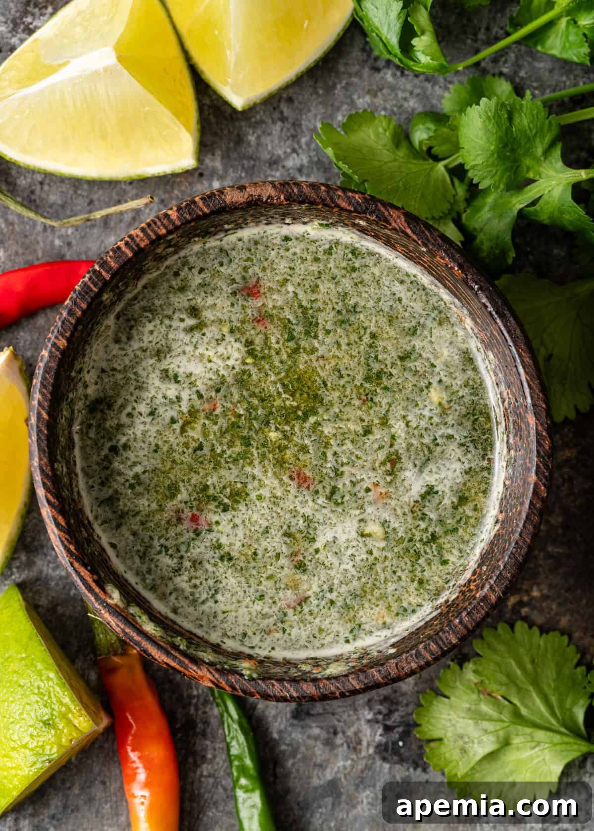 overhead: thai dipping sauce with fresh herbs in a small wooden bowl, ready to serve