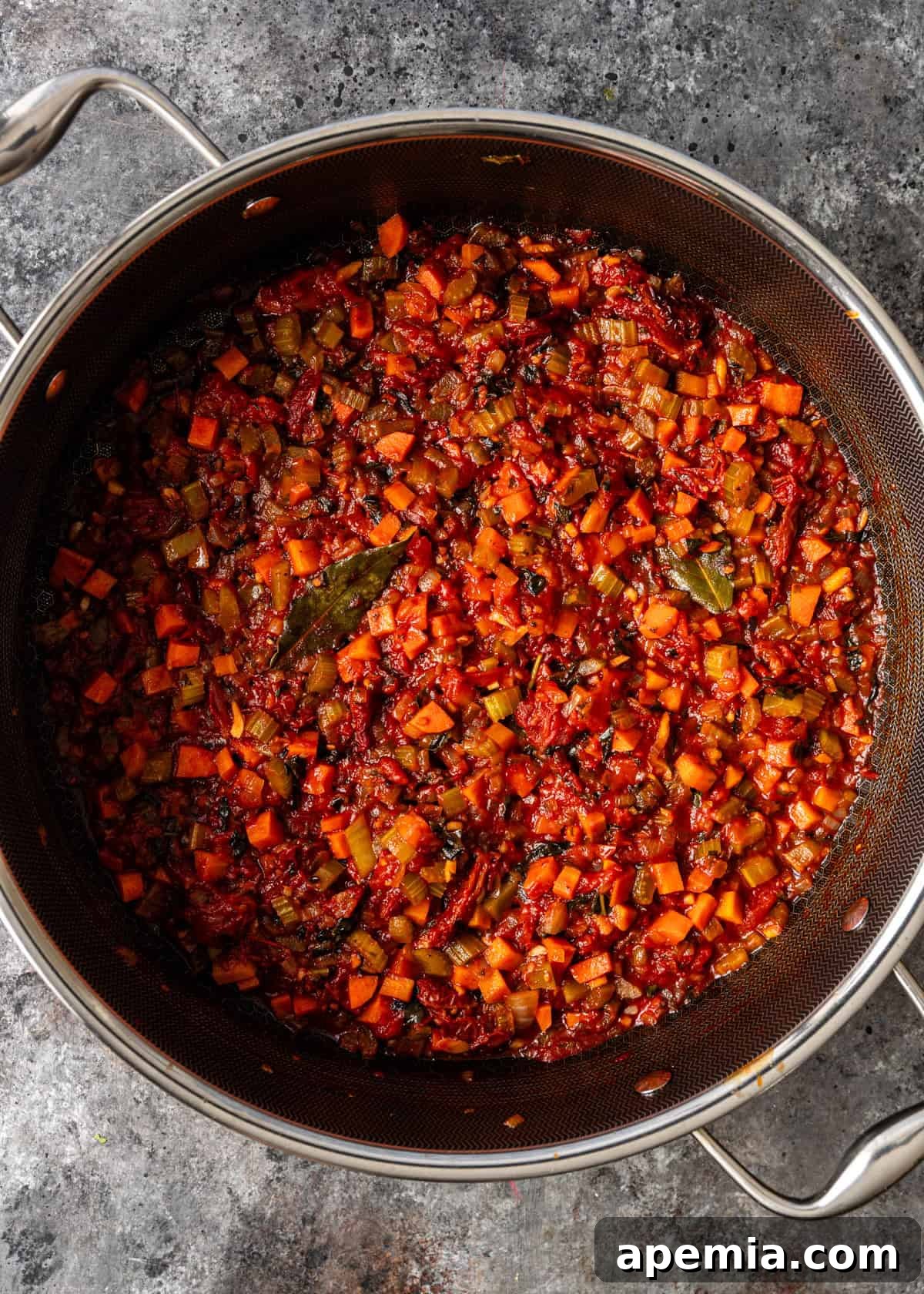 overhead process shot: large deep skillet on countertop with the simmering vegetable ragu