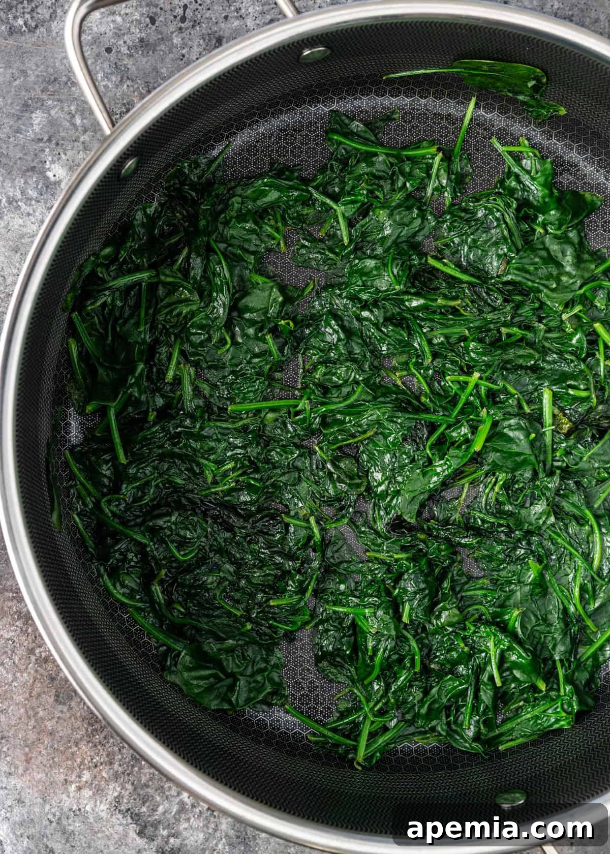 overhead process shot: spinach in olive oil in skillet