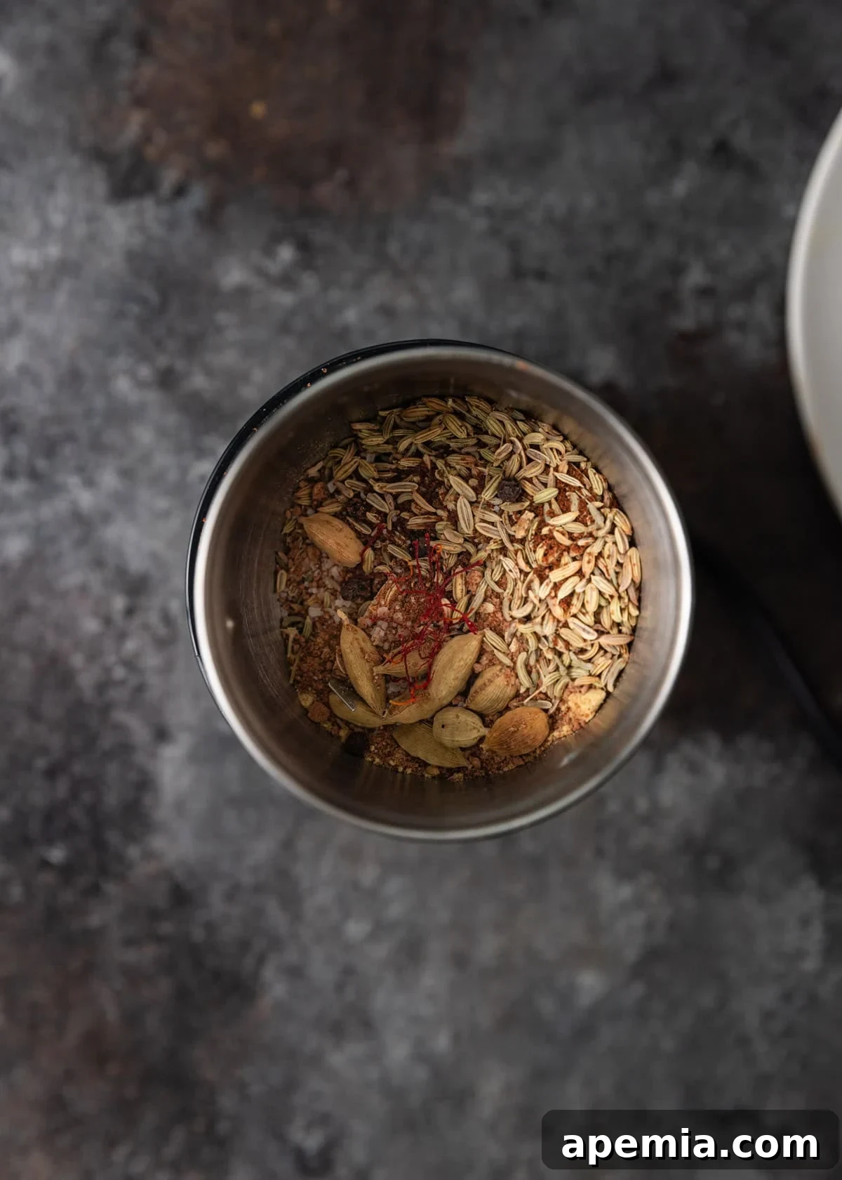 overhead process shot: spices in silver spice grinder