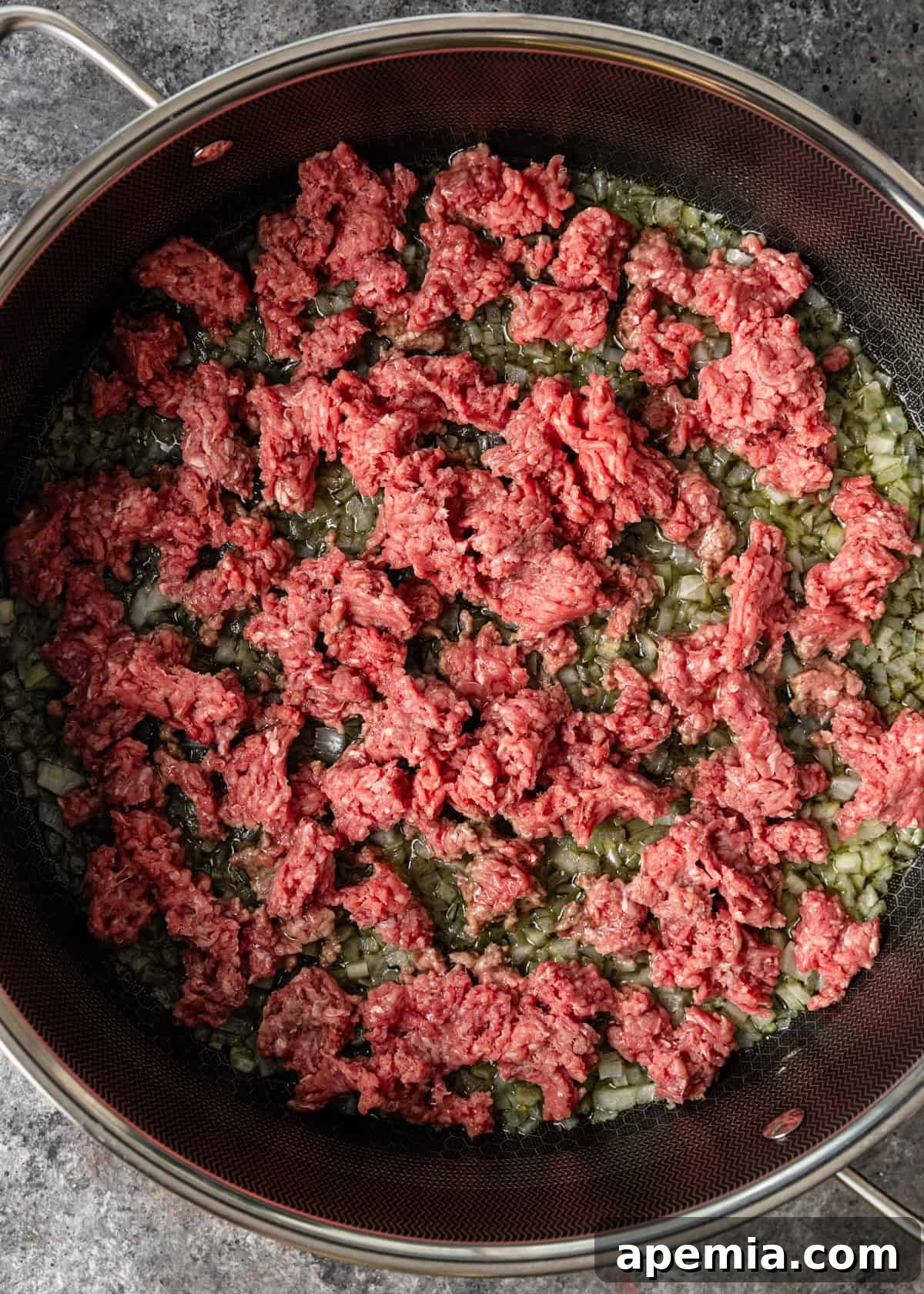 overhead process shot: ground beef and onions in deep skillet