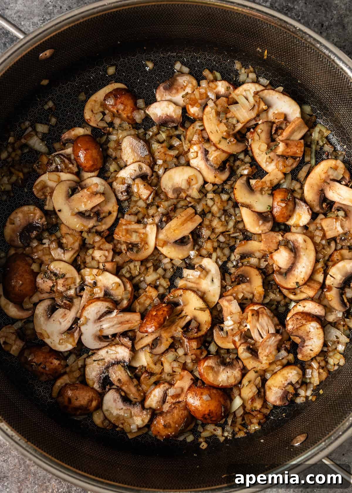 overhead process shot: diced onions and sliced mushrooms cooking in skillet