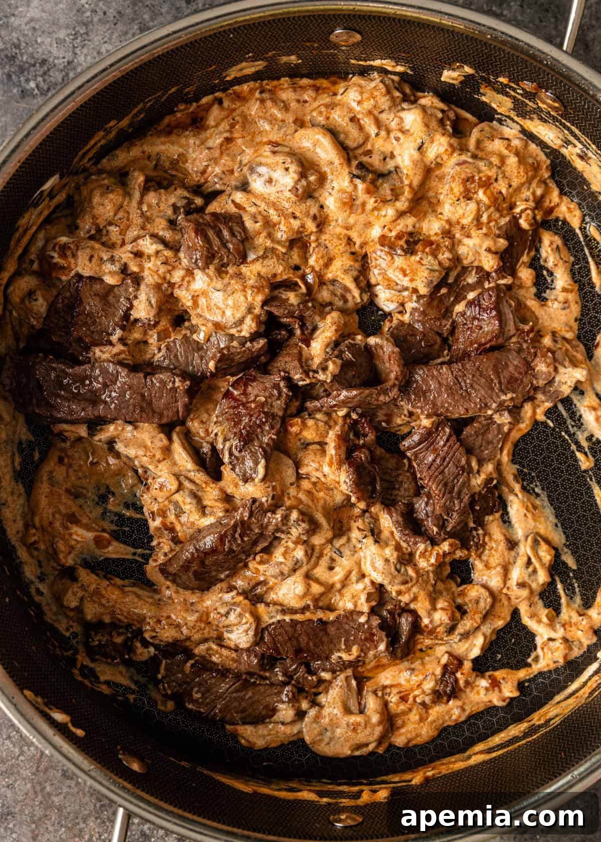 closeup overhead: beef stroganoff cooking in skillet