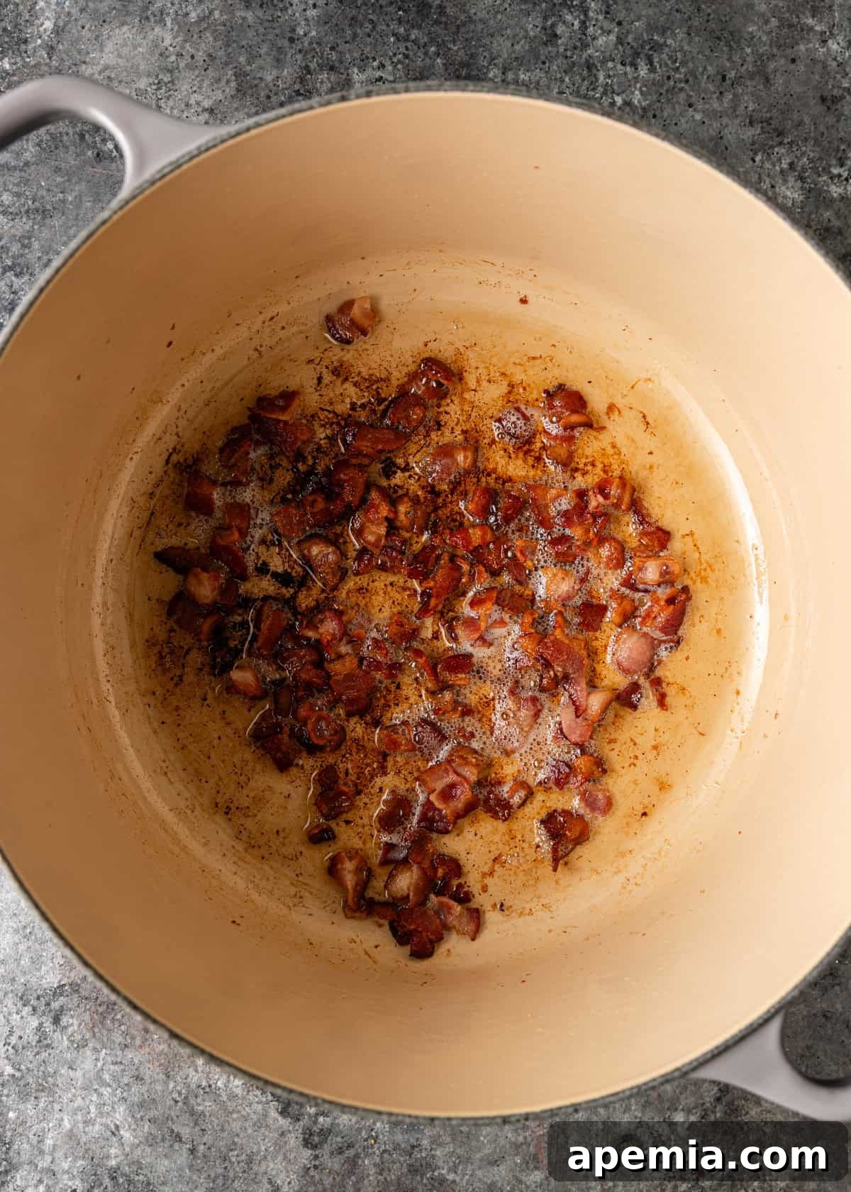 overhead process shot: cooked chopped bacon in dutch oven