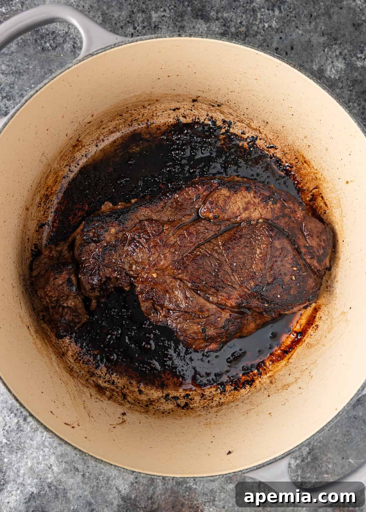 overhead process shot: browned beef in dutch oven with bacon fat