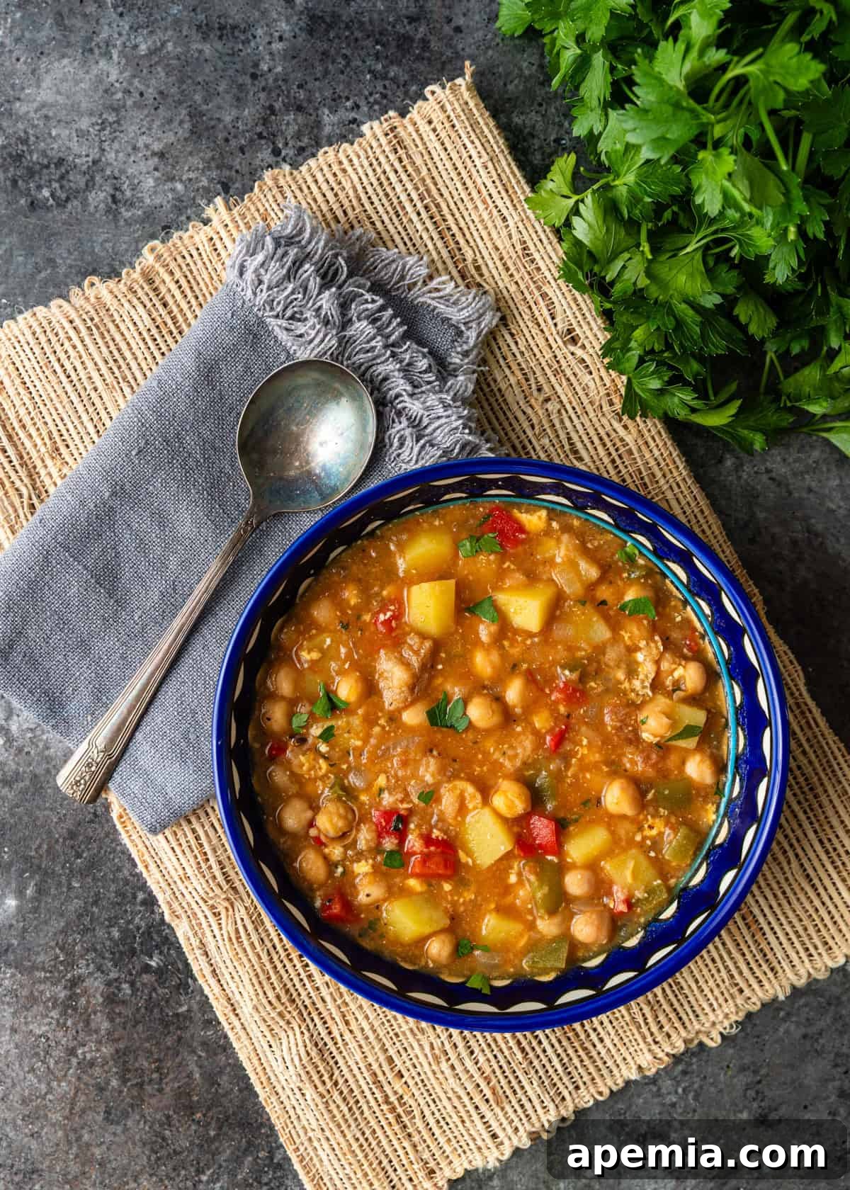 overhead: ready to serve potaje de garbanzos in white and blue bowl with spoon on side