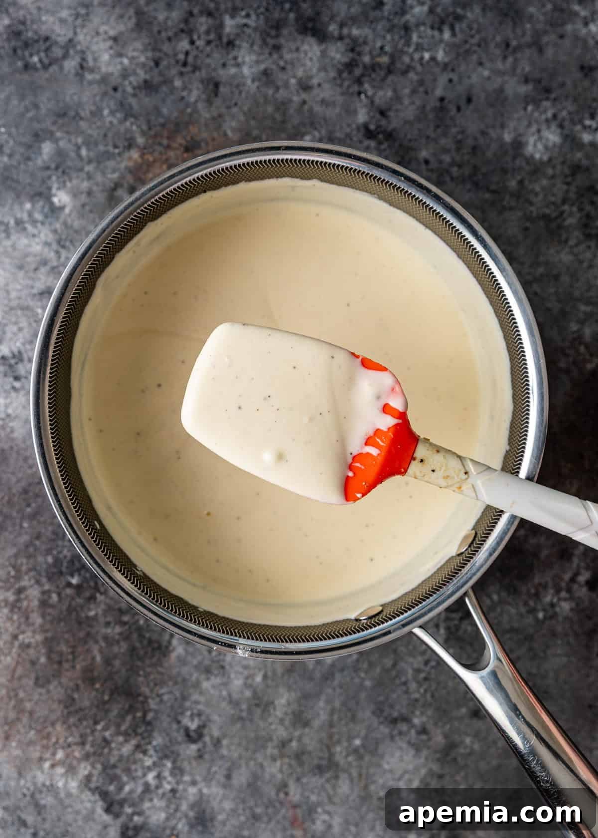 overhead process shot: yogurt-egg sauce in pan with spatula