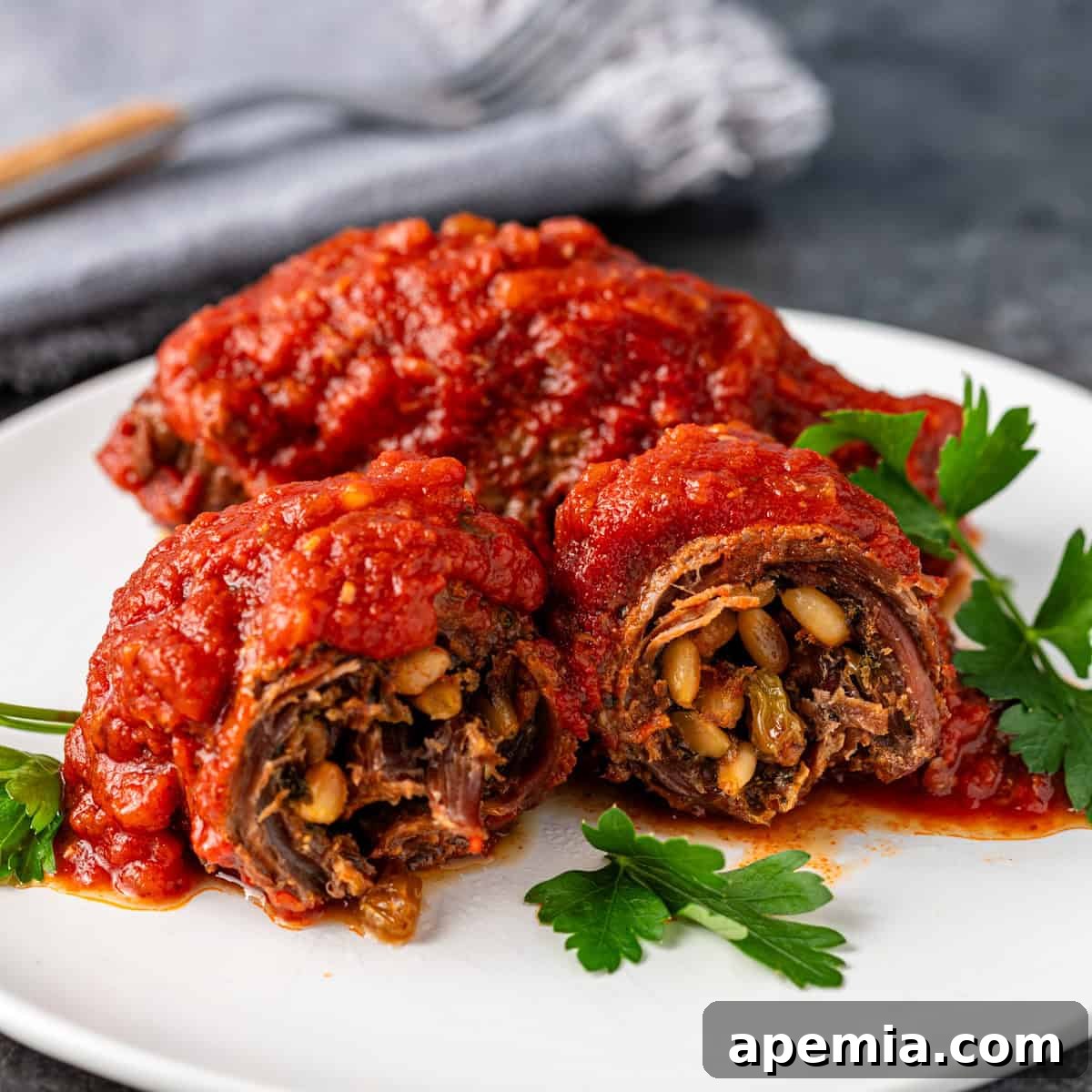 closeup side view: braciole on white plate