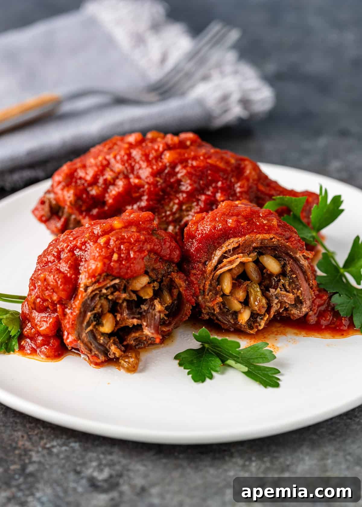 closeup side view: braciole on white plate