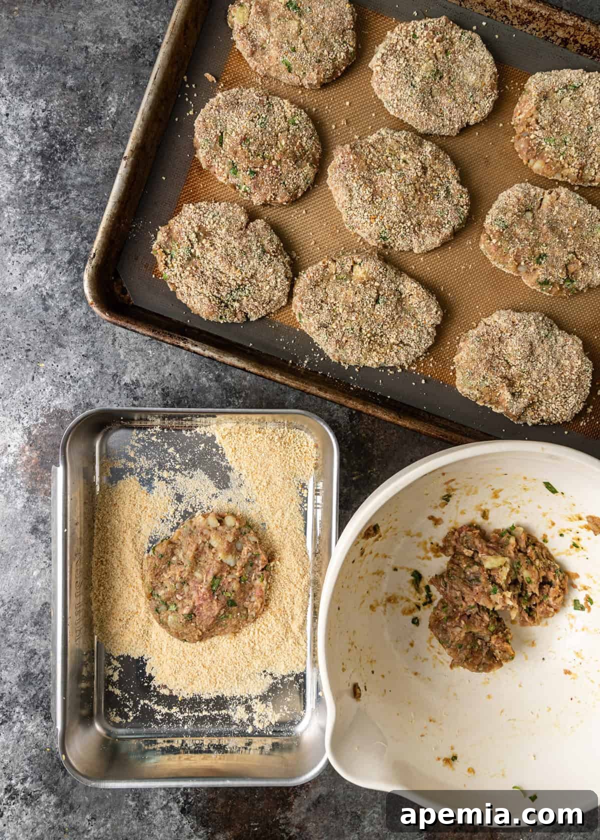 overhead process shot: individual patties on baking sheet with one patty in breadcrumbs pan and mixing bowl with extra ingredients