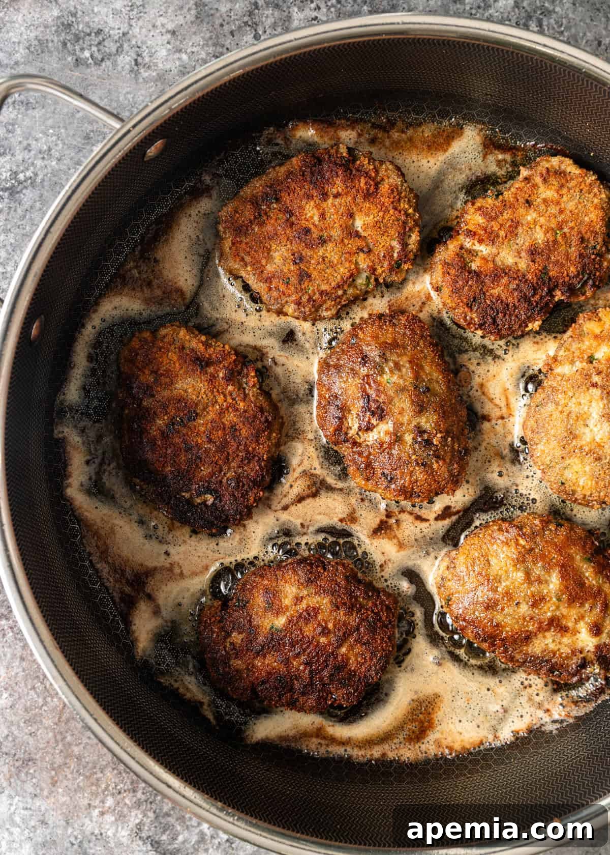 overhead process shot: kotlet cooking in skillet