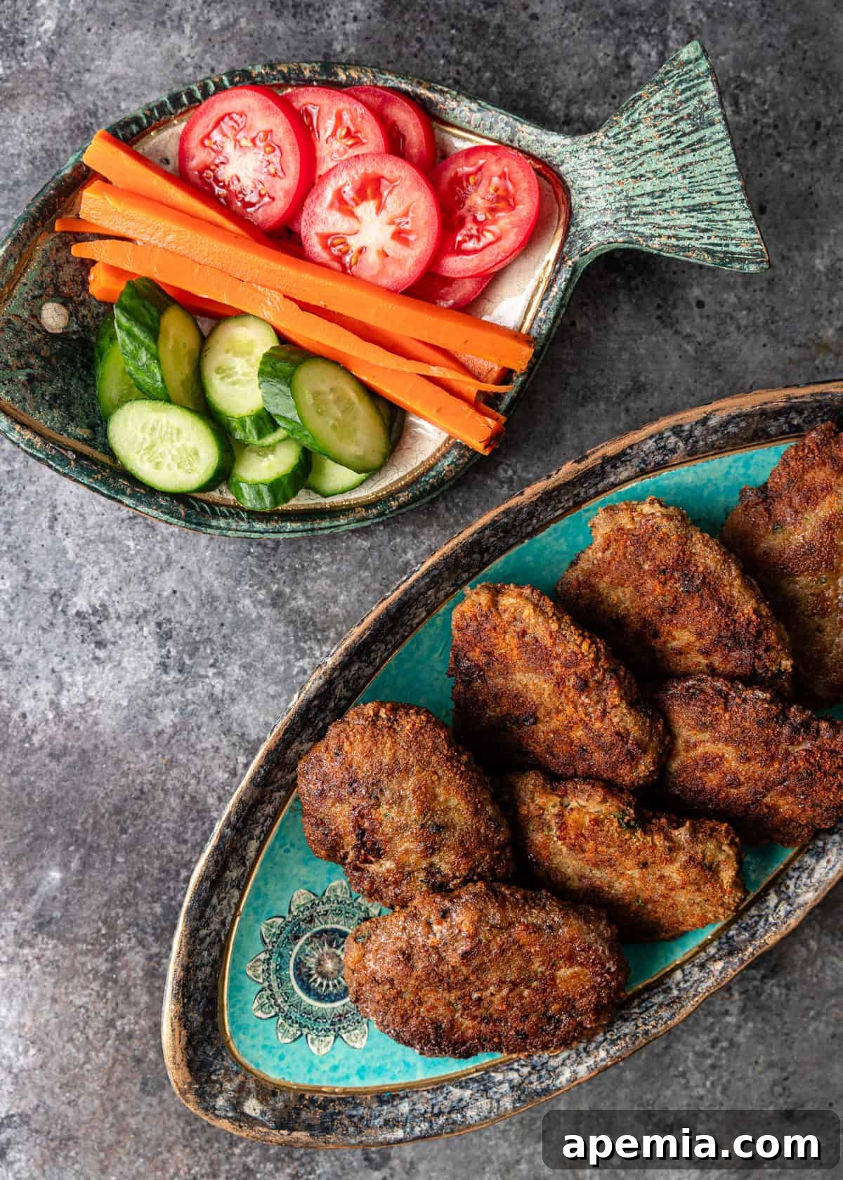 overhead: ready to serve kotlet on colorful serving dish with side dish of cucumbers, carrots, and tomatoes