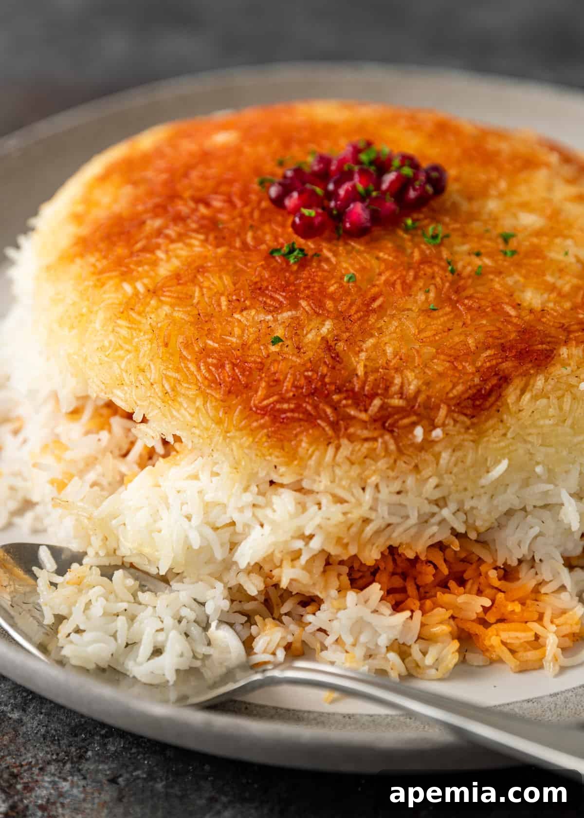 plated dish of tahdig rice garnished with pomegranate arils