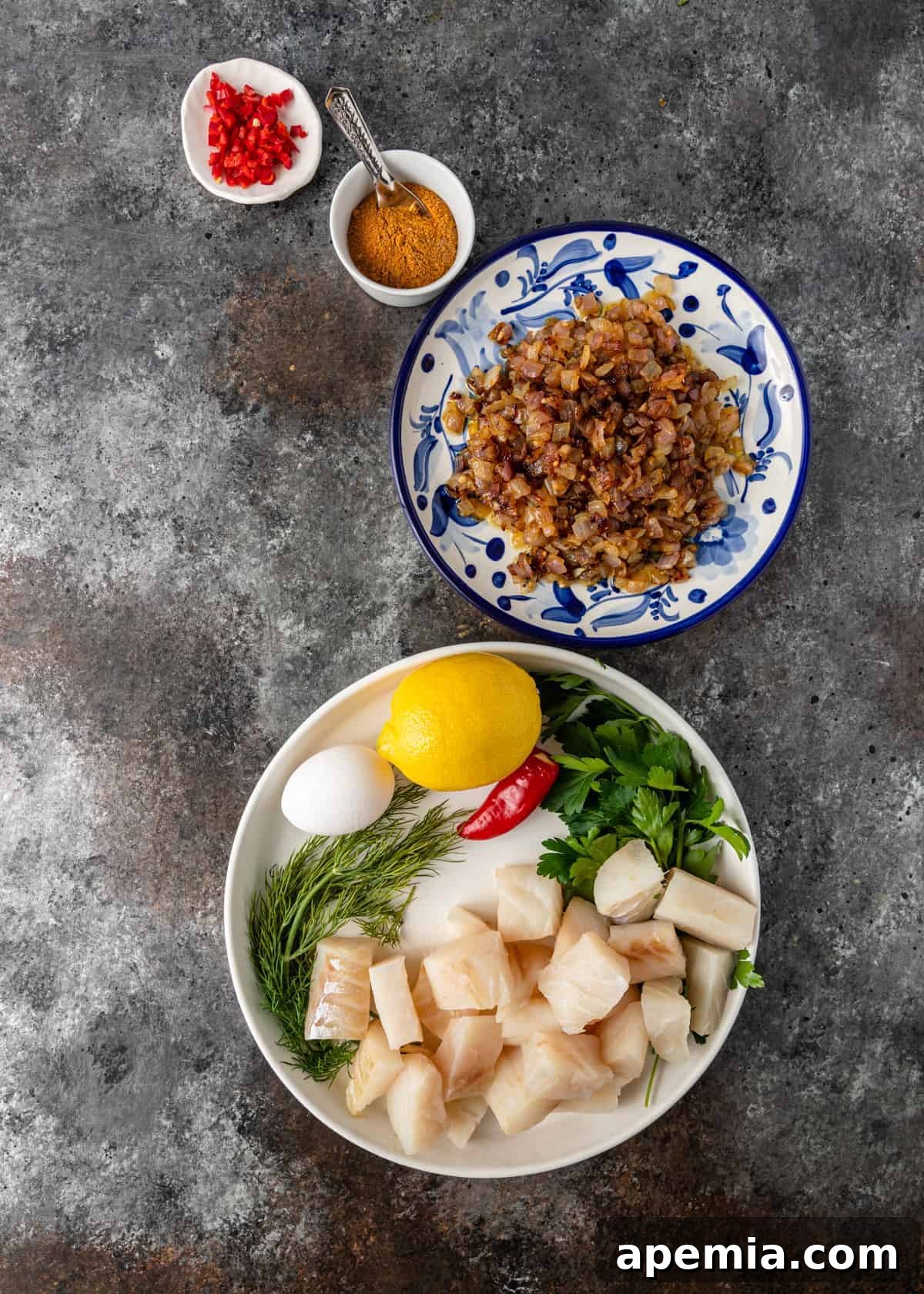 Overhead shot displaying all the fresh ingredients, meticulously arranged on various plates, ready for making the fish meatball recipe.