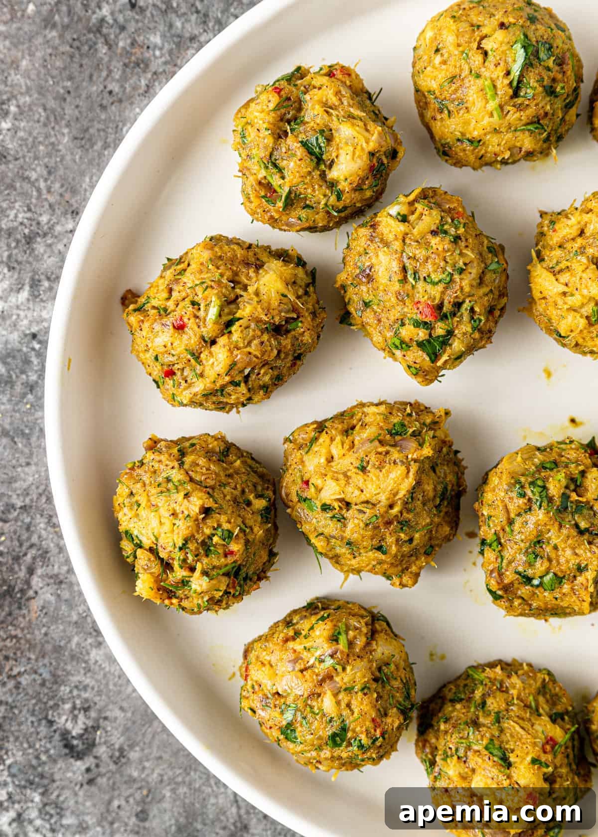 Overhead view of Palestinian fish meatballs neatly arranged on a plate, perfectly shaped and ready for pan-frying.