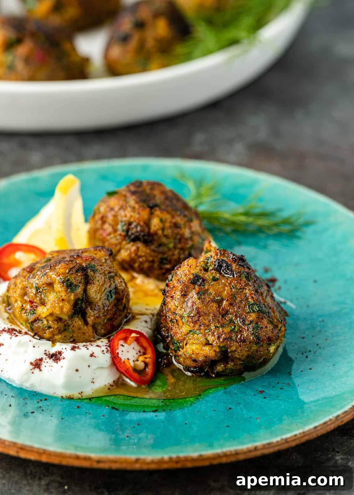 A beautifully presented dish of Middle Eastern fish meatballs nestled in creamy homemade labneh, ready to be enjoyed.