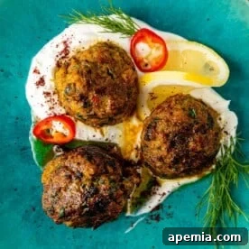 overhead: 3 fish meatballs sitting in homemade labneh on a blue plate