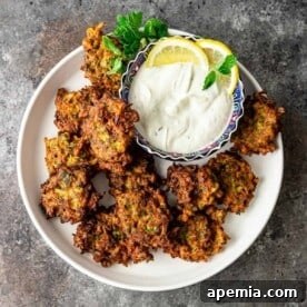 Lemon-Kissed Cauliflower Crisps 8 overhead: middle eastern side dish: fried vegetable patties with bowl of mint yogurt sauce for dipping