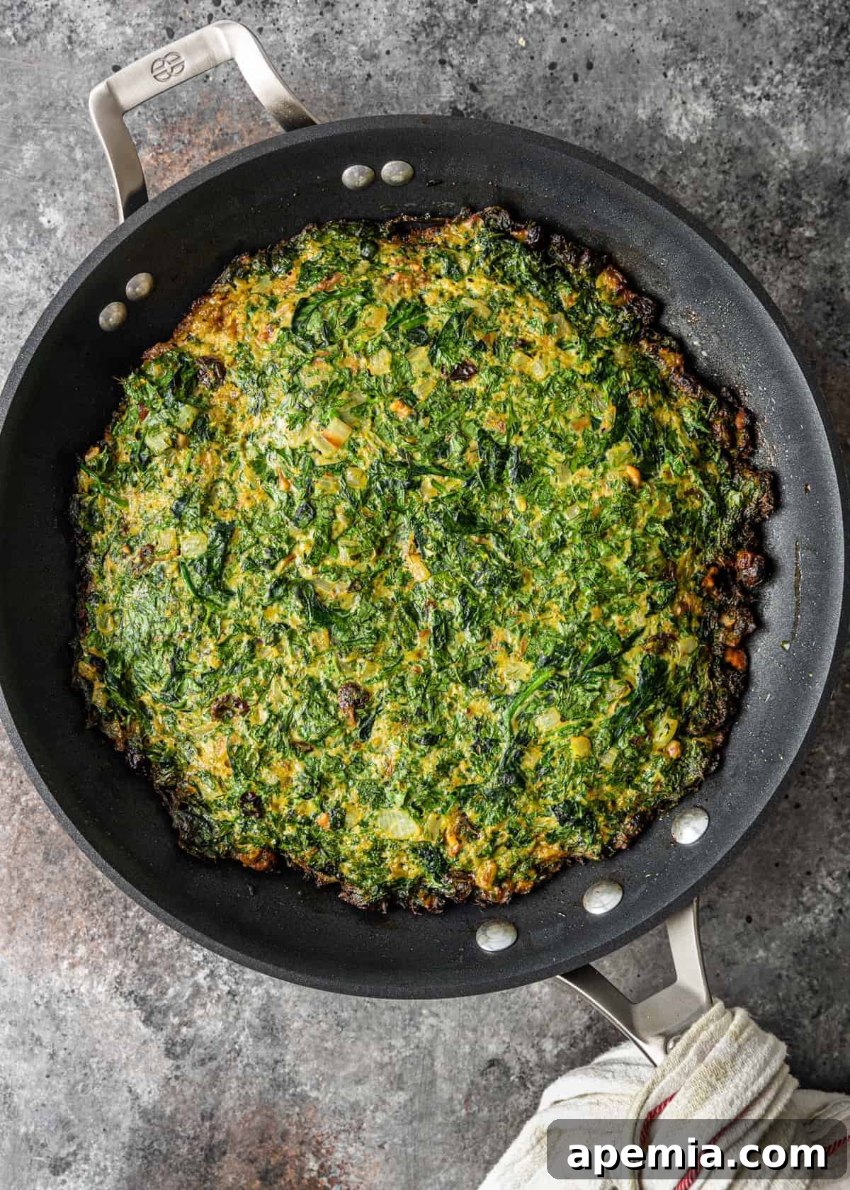 Close-up of Kookoo Sabzi cooked to perfection in a cast-iron pan, ready to be served.