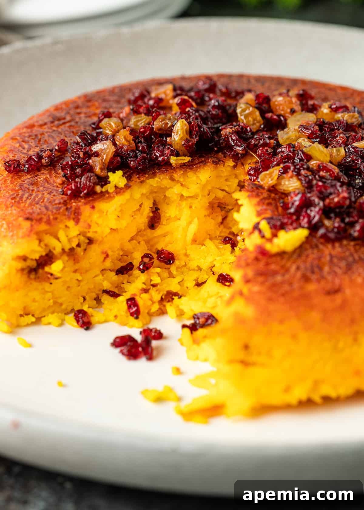closeup side view: baked crispy Persian rice on white plate