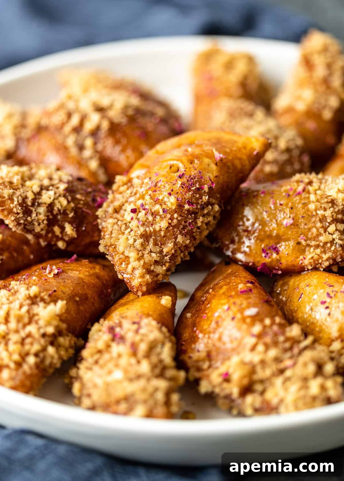 platter of fried Katayef for Ramadan iftar dipped in crushed walnuts